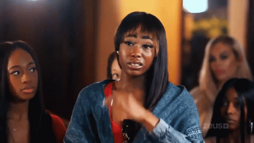 A Group Of Women Are Sitting In A Room And One Of Them Is Making A Face . GIF