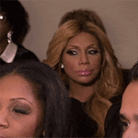 A Group Of Women Are Sitting In A Room And One Woman Is Looking At The Camera . GIF