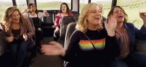 A Group Of Women Are Sitting On A Bus And Laughing . GIF