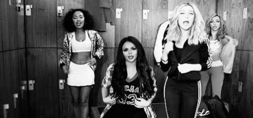 A Group Of Women Are Standing In A Locker Room Dancing . GIF