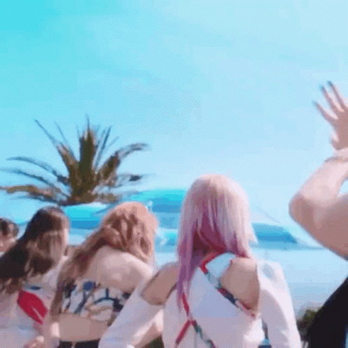 A Group Of Women Are Standing In Front Of A Palm Tree . GIF