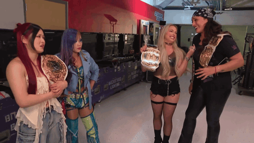 A Group Of Women Are Standing In Front Of A Sign That Says " Locker Room " GIF