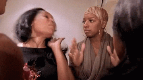 A Group Of Women Are Standing Next To Each Other Having A Conversation . GIF
