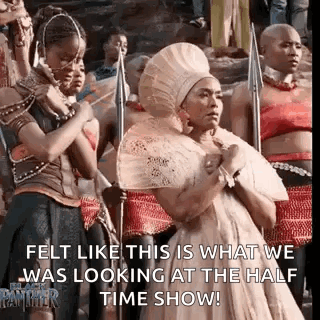 A Group Of Women Are Standing Next To Each Other In A Line Holding Spears And A Fan . GIF