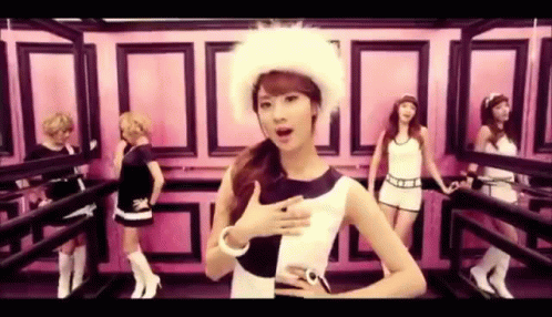 A Group Of Women Are Standing Next To Each Other In A Room . One Of The Women Is Wearing A Fur Hat . GIF