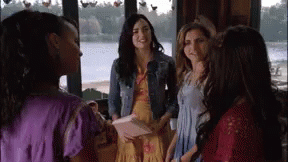 A Group Of Women Are Standing Next To Each Other In Front Of A Window In A Room . GIF