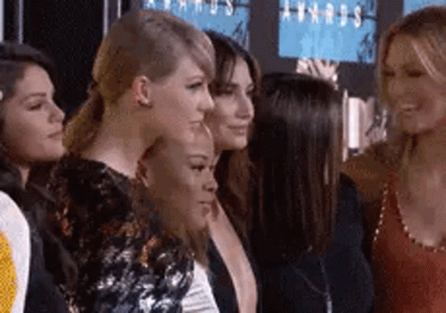 A Group Of Women Are Standing Next To Each Other On A Red Carpet At An Event . GIF