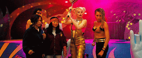 A Group Of Women Are Standing Next To Each Other On A Stage Holding A Microphone . GIF