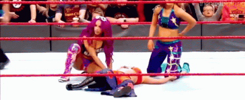 A Group Of Women Are Wrestling In A Ring While A Baby Is Watching . GIF