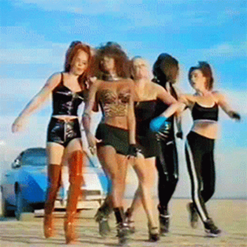 A Group Of Women Dancing In Front Of A Car GIF