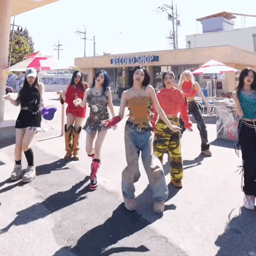 A Group Of Women Dancing In Front Of A Record Shop GIF