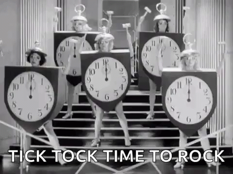 A Group Of Women Dressed As Clocks Are Dancing On Steps . GIF