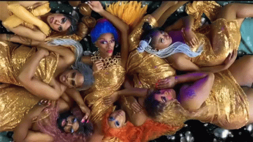 A Group Of Women In Gold Dresses Are Laying Down GIF