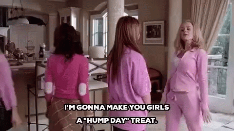 A Group Of Women In Pink Clothes Are Standing In A Living Room Talking To Each Other . GIF