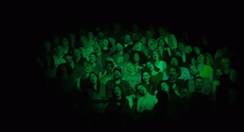 A Group Of Women Singing In Front Of Microphones On A Stage GIF