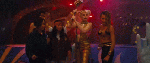 A Group Of Women Standing Next To Each Other On A Stage In A Dark Room . GIF