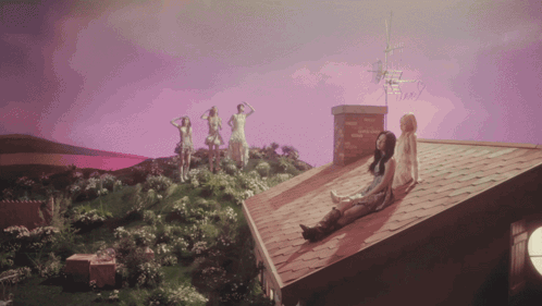 A Group Of Women Standing On Top Of A Roof With A Purple Sky In The Background GIF