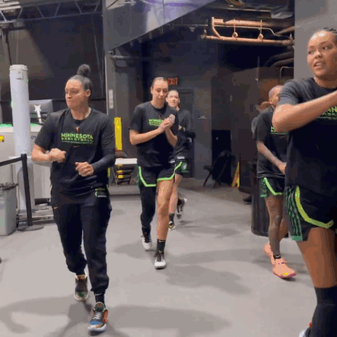 A Group Of Women Wearing Minnesota Basketball Shirts Are Running In A Gym GIF