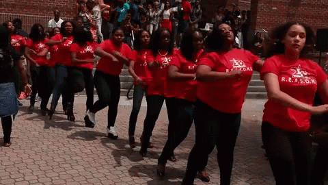 A Group Of Women Wearing Red Shirts With R.e.a.s.g.n. On Them GIF