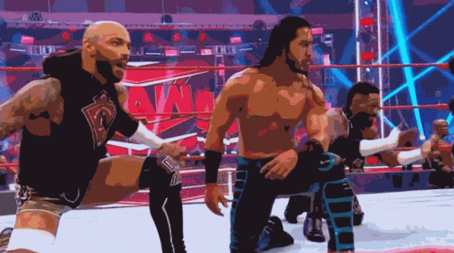 A Group Of Wrestlers Are Kneeling Down In Front Of A Ring That Says Wwe GIF