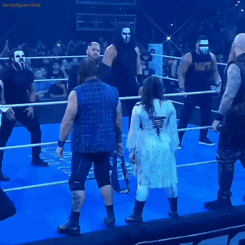 A Group Of Wrestlers Are Standing In A Ring And One Of Them Is Wearing A Shirt That Says Mcw GIF