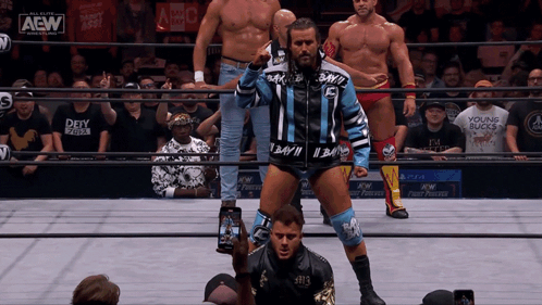 Wrestlers Standing In Ring With AEW Logo GIF