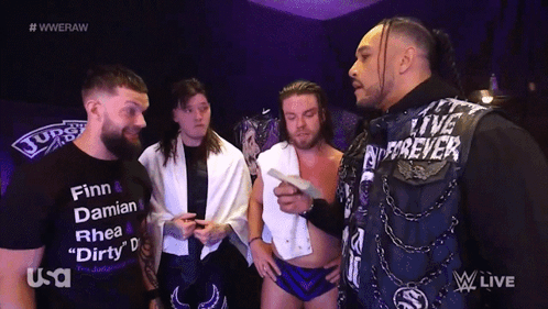A Group Of Wrestlers Are Standing In Front Of A Screen That Says Wweraw GIF