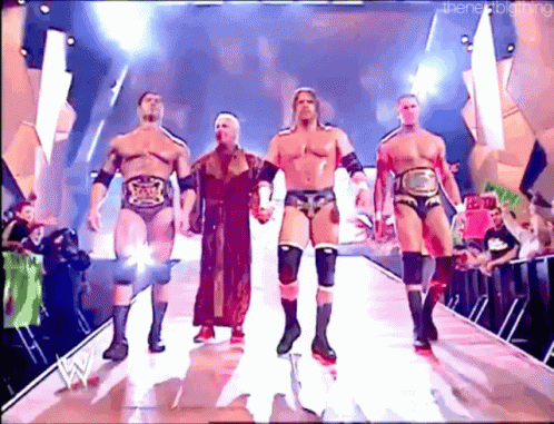 A Group Of Wrestlers Are Walking Down A Ramp Holding Hands GIF