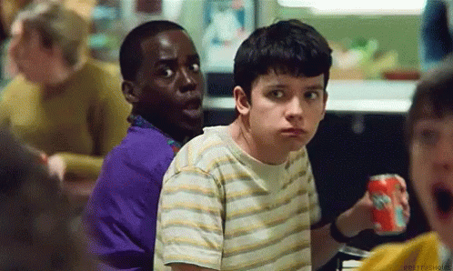 A Group Of Young Boys Are Sitting At A Table In A Restaurant . One Of The Boys Is Holding A Soda Can . GIF
