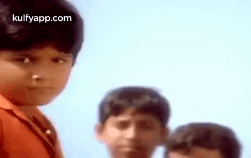 A Group Of Young Boys Are Standing Next To Each Other And One Of Them Is Looking At The Camera . GIF