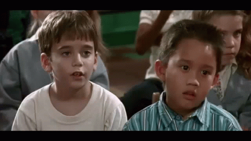A Group Of Young Children Are Sitting In A Classroom And Looking At Something . GIF