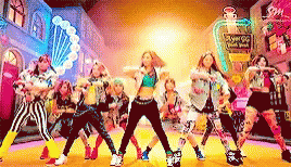 A Group Of Young Girls Are Dancing In Front Of A Perfume Bottle That Says Angel G GIF