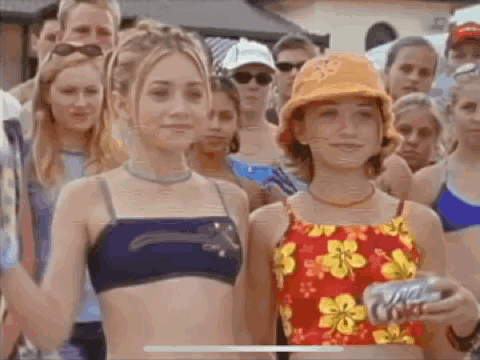 A Group Of Young Girls In Bikinis Are Standing Next To Each Other In Front Of A Crowd Of People . GIF