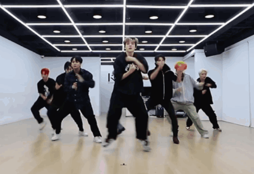 A Group Of Young Men Are Dancing In A Dance Studio With The Letter K On The Ceiling GIF