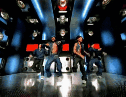 A Group Of Young Men Are Dancing In A Dark Room GIF