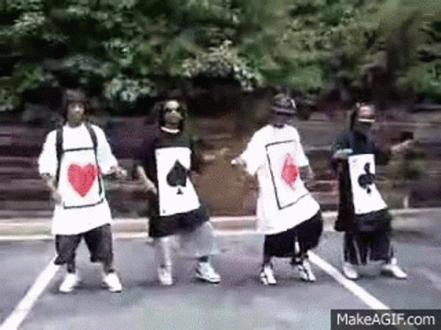 A Group Of Young Men Are Dancing In A Parking Lot While Wearing Playing Cards Shirts . GIF