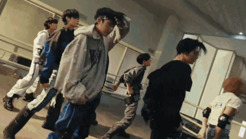 a group of young men are dancing in a room and one of them is wearing a hoodie that says n.y.c.