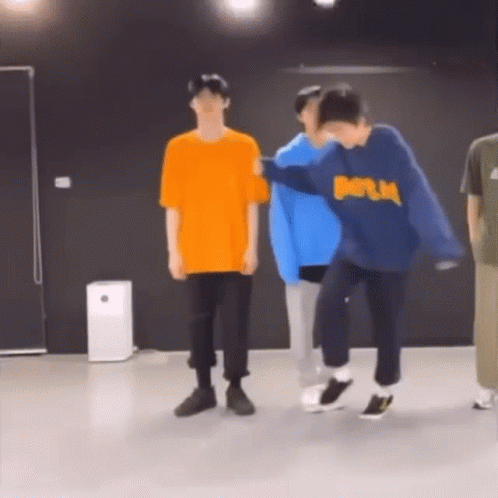 A Group Of Young Men Are Dancing In A Room . GIF