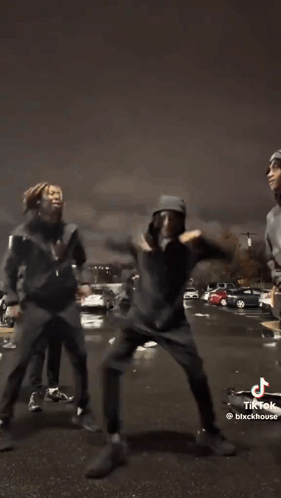 A Group Of Young Men Are Dancing In Front Of A Car In A Tik Tok Video . GIF