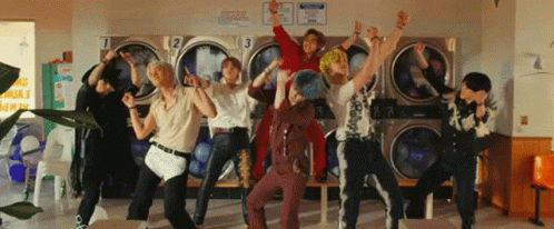A Group Of Young Men Are Dancing In Front Of A Laundromat With Numbers 1 2 And 3 On Them GIF