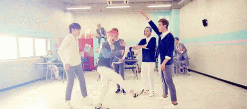 A Group Of Young Men Are Dancing Together In A Room In A School . GIF