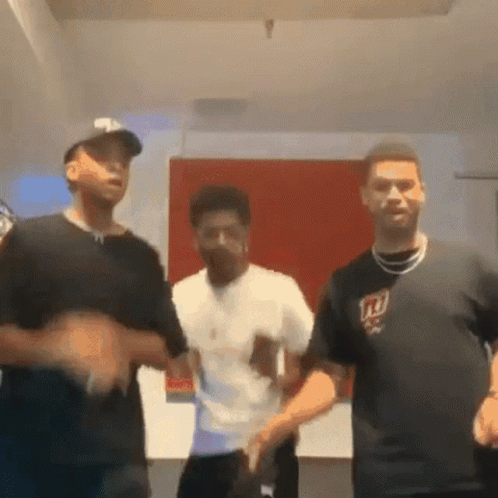A Group Of Young Men Are Dancing Together In A Room . One Of The Men Is Wearing A Ny Giants Shirt . GIF