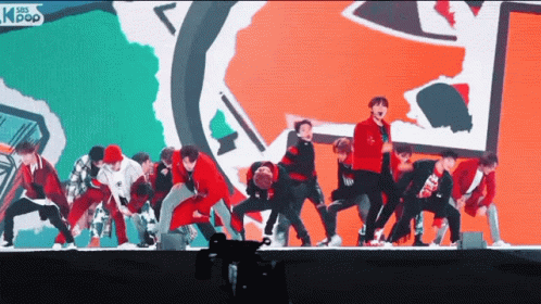 a group of young men are performing on a stage with asian pop written on the bottom