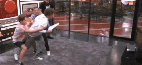 A Group Of Young Men Are Playing A Video Game In A Room . GIF