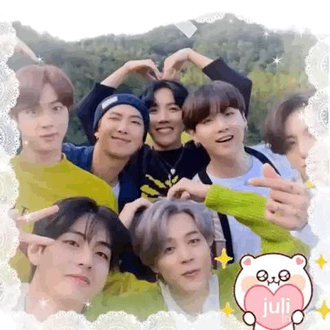A Group Of Young Men Are Posing For A Picture And Making A Heart With Their Hands . GIF