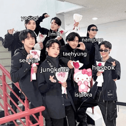 A Group Of Young Men Are Posing For A Picture And One Of Them Is Holding A Hello Kitty Item GIF