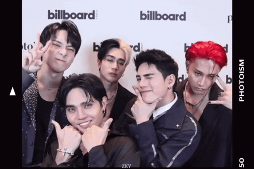 A Group Of Young Men Are Posing For A Picture In Front Of A Billboard Sign GIF