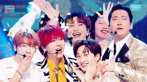 A Group Of Young Men Are Posing For A Picture On A Stage . GIF