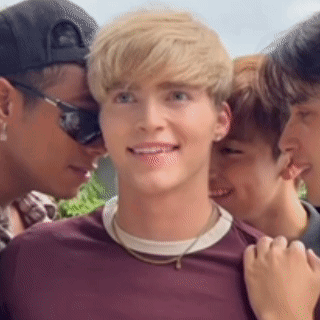 a group of young men are posing for a picture . one of the men is wearing sunglasses .