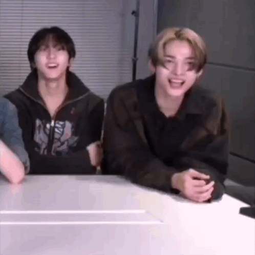 A Group Of Young Men Are Sitting At A Table Laughing And Smiling . GIF